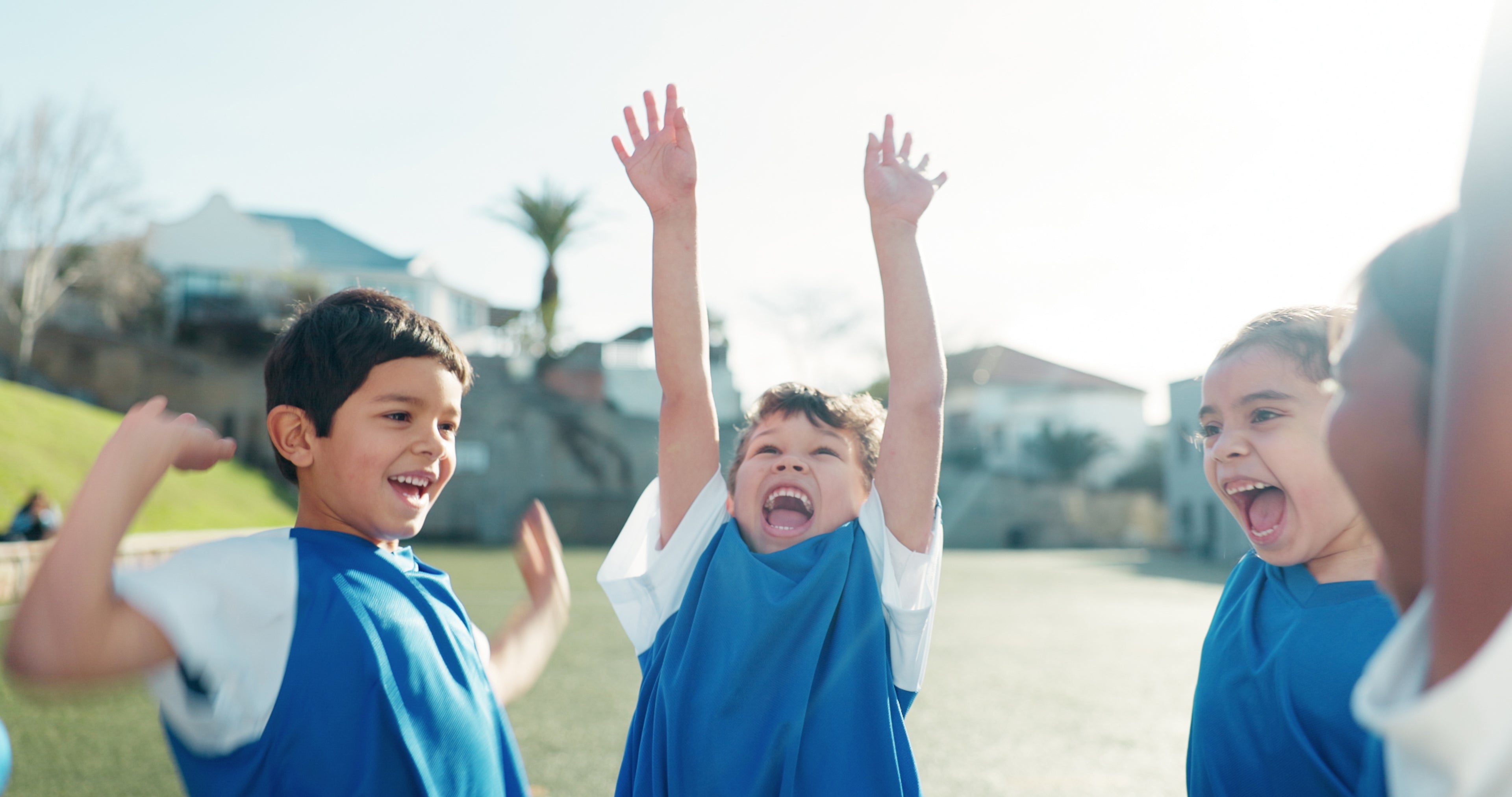 Children thriving and reaching their full potential, shown celebrating joyfully on a sports field. This image represents the active childhood that the iKids-Growth supplement helps to support.